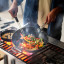 Joseph Joseph Space Ceramic Non-Stick Blue Wok with Folding Handle, 32cm on the stove with stir fry