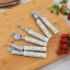 Laura Ashley Stainless Steel Ice Cream Spoon with Ceramic Handle - Sage Parterre on a chopping board