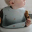 Mushie Silicone Baby Bib - Retro Cars worn by a baby