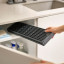 Joseph Joseph Platform Foldable Over-Sink Drainer stored in a cupboard