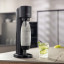 Sodastream Gaia Black Sparkling Water Maker with a glass of sparkling water