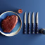 Wusthof Classic Colours Wild Blueberry Steak Knives Set, 4-Piece on the table with meat