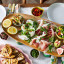 Jamie Oliver Big Love Mango Wood Board, 57cm on the table with food