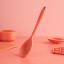 Fusion Twist Silicone Solid Spoon - Coral on the table
