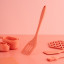 Fusion Twist Silicone Slotted Turner - Coral on the table