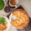 Artisan Street Round Pie Dish, 24cm with a pie on the table
