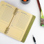 Kikkerland Habit Tracker Notebook opened on the table