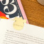 Kikkerland 3-in-1 Metal Paperclips on a page in a book