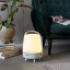Kooduu Lite-Up Play JBL Speaker & Lamp - White/Sand next to a couch