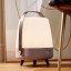 Kooduu Lite-Up Play JBL Speaker & Lamp - White/Earth next to a chair