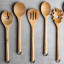 KitchenAid Birchwood Pasta Server & Fork on the table with other utensils