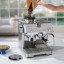DeLonghi La Specialista Opera Manual Pump Espresso Coffee Machine, EC9555.M on the kitchen island with coffee beans
