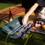 Joseph Joseph GrillOut Stainless-Steel BBQ Utensil Set with Storage Case, Set of 4 next to a grill