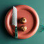 Wusthof Classic Colours Rosemary Hollow Edge Santoku, 17cm on a plate