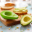 Food Huggers Avocado Huggers, Set of 2 on a board with avo