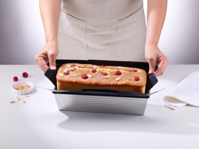 NoStik Reusable Cake Tin Liner, Rectangular with cake lifting out of loaf tin
