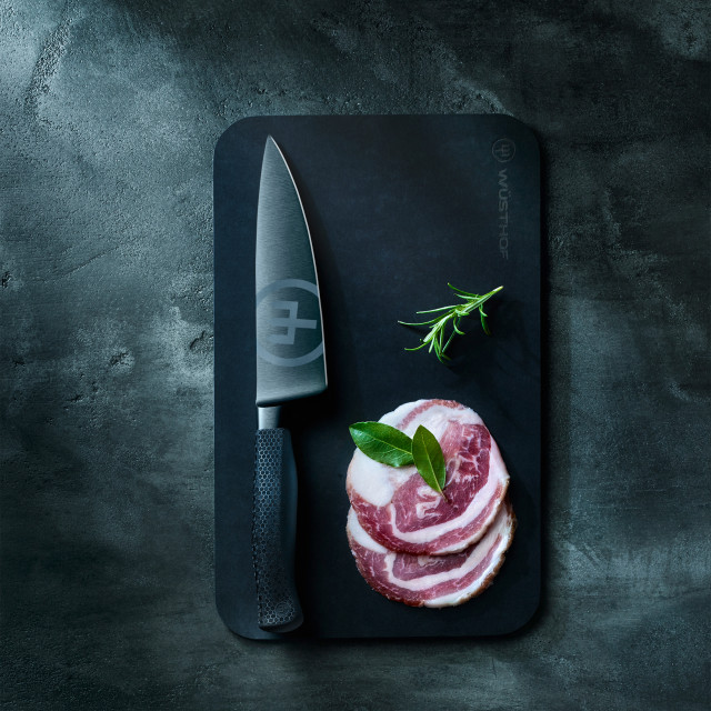 WÃ¼sthof Performer Cooks Knife, 17cm on a chopping board next to sliced meat