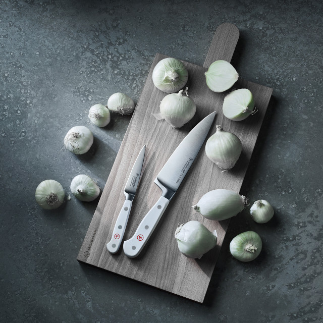 Wüsthof CLASSIC WHITE Cooks Knife, 16cm on a chopping board next to vegetables