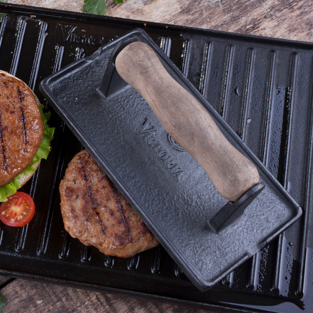 Victoria Matte Black Enamelled Cast Iron Bacon & Meat Press with Wooden Handle in use