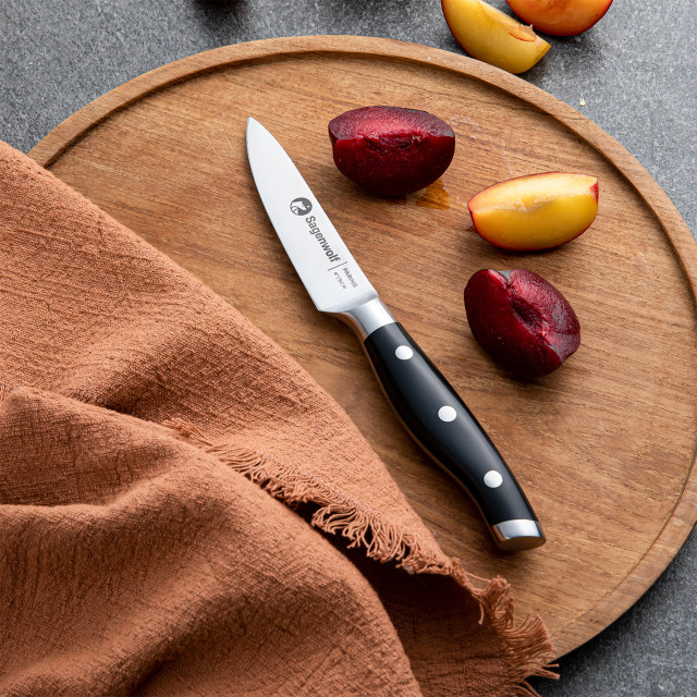 Sagenwolf Performance Paring Knife, 9cm on a wooden board with sliced plums