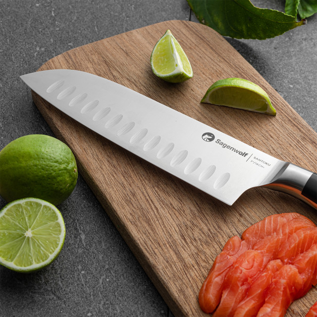Sagenwolf Performance Santoku Knife, 18cm close up of blade on a wooden board with sliced salmon and lime