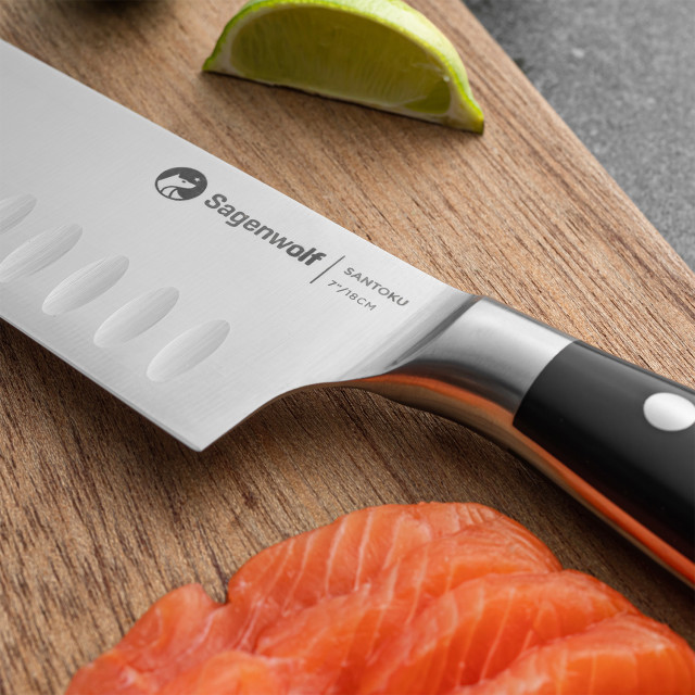 Sagenwolf Performance Santoku Knife, 18cm close up of blade and handle on a wooden board with sliced salmon and lime