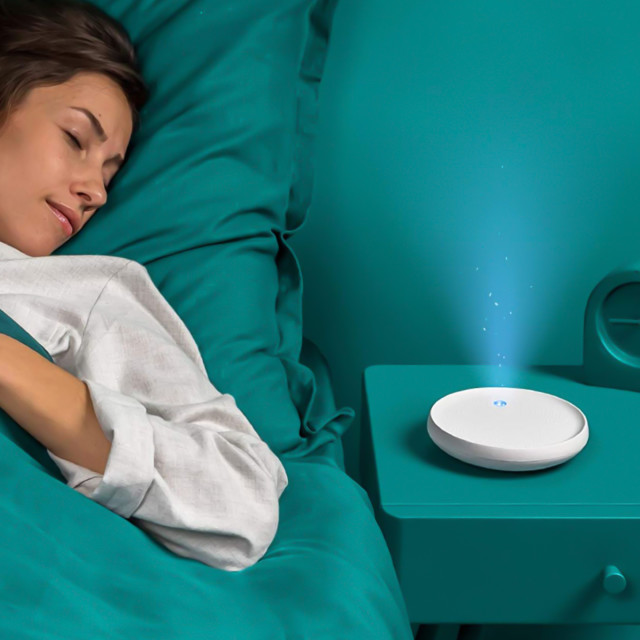Dodow Sleep Aid Device In a bedroom setting with a person sleeping