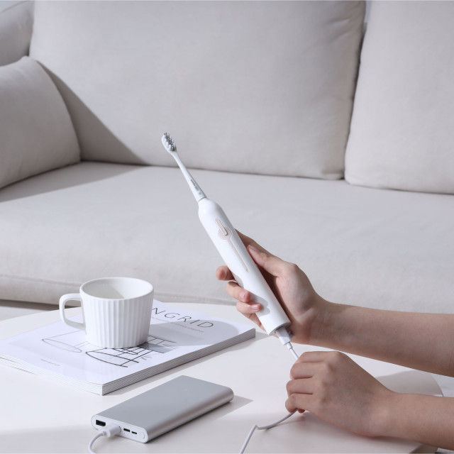 Usmile Sonic Electric Toothbrush P1 - White on the table charging