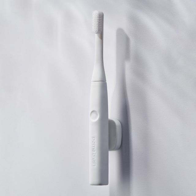 PomaDent PomaClip Magnetic Toothbrush Holder - White on the wall with the toothbrush