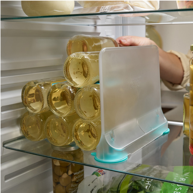 Joseph Joseph FridgeStore Shelf Divider in the fridge with stacked bottles of refreshments