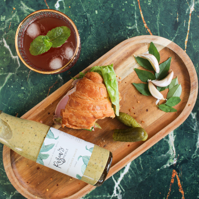 Razias Pickle Medium Spice Curry Leaves Sauce, 250ml with food on the table