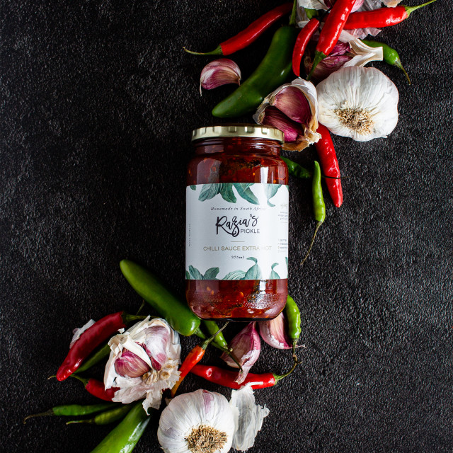 Razias Pickle Extra Hot Chilli Sauce, 375ml with chilli and garlic on the table