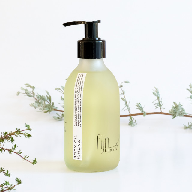 Fijn Botanicals Kingna Body Oil, 200ml on a table surrounded by foliage