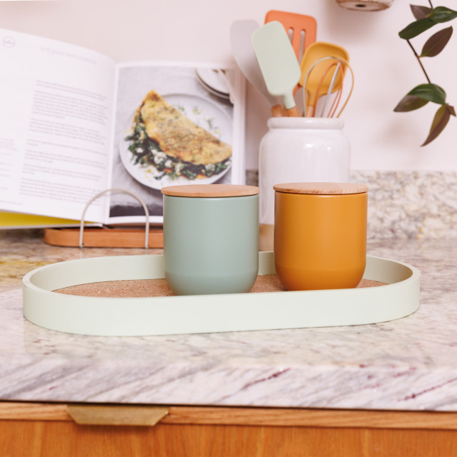 KitchenCraft Idilica Metal Storage Canister, 450ml - Green with a yellow canister on a tray
