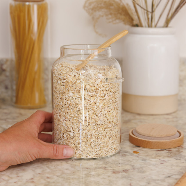 KitchenCraft Idilica Glass Storage Jar with Beechwood Lid and Bamboo Spoon on the table