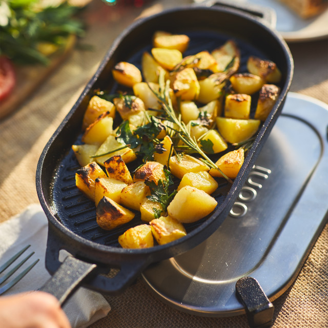 Ooni Cast Iron Sizzler Pan with Stainless Steel Trivet Base on the table with food