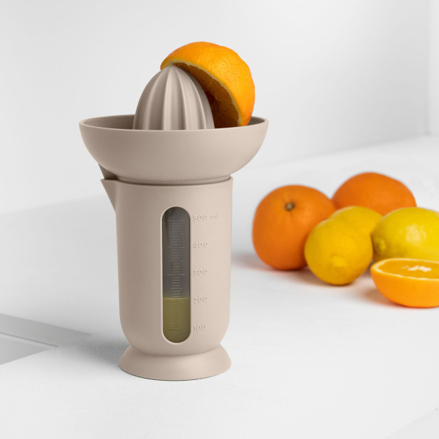 Blim Plus UFO Juicer with QB Jug - Moka Grey on the table with oranges
