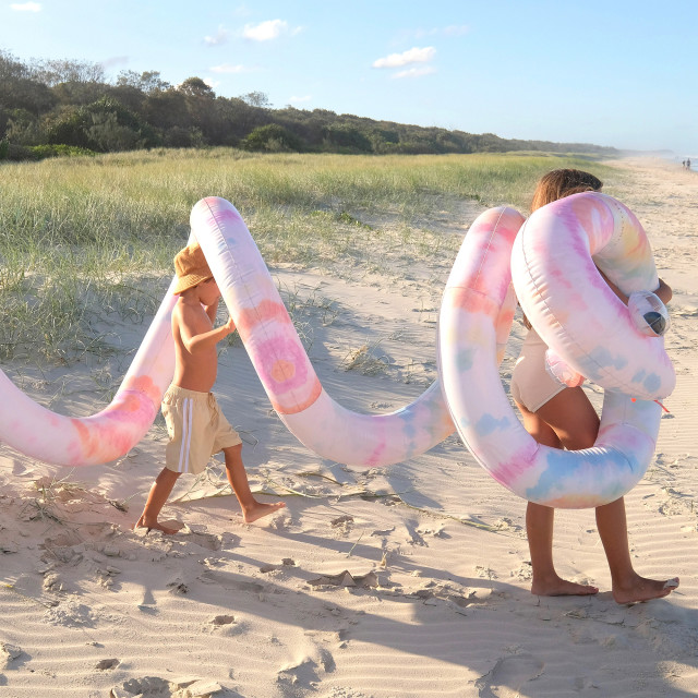 Sunnylife Giant Inflatable Noodle Snake - Tie Dye at the beach