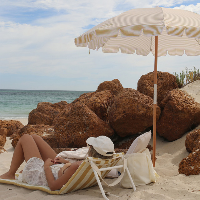 Sunnylife Beach Umbrella - Mango Bay Golden Mustard Stripe at the beach