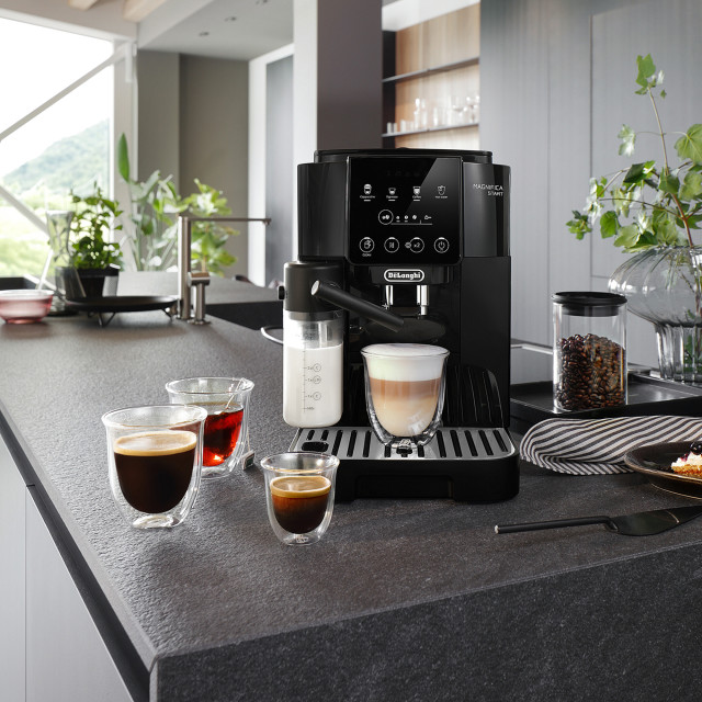 DeLonghi Magnifica Start with Milk Bean-to-Cup Coffee Machine on the kitchen counter with cups of coffee and tea