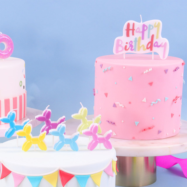 PME Multicolour Happy Birthday Candle - Pink on a cake