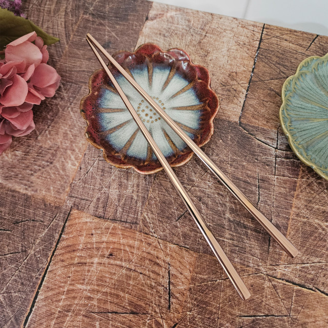 Nicolson Russell Stainless Steel Chopsticks, Set of 2 - Rose Gold on the table