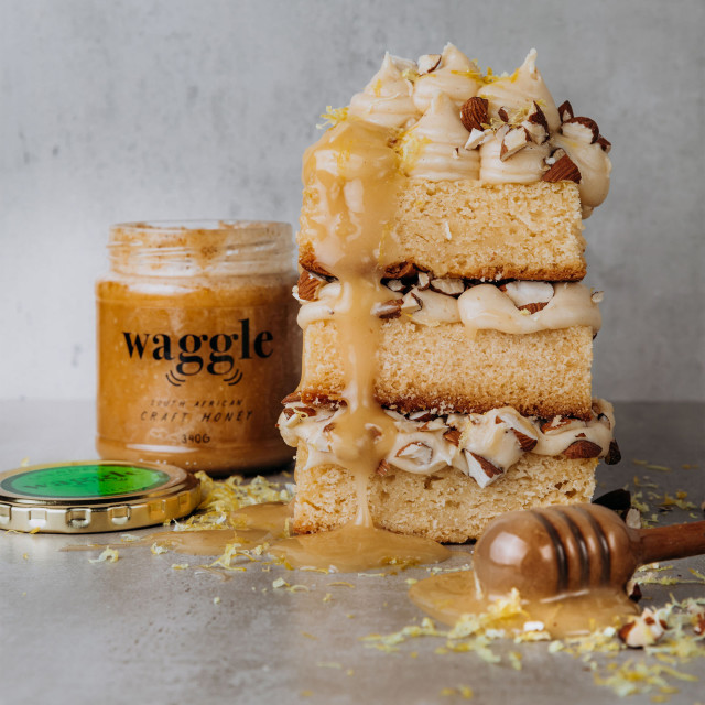 Waggle Spiced Craft Honey, 340g with a slice of cake