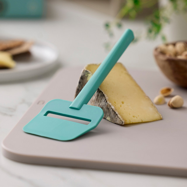 Rosti Emma Cheese Slicer - Green with a slice of cheese