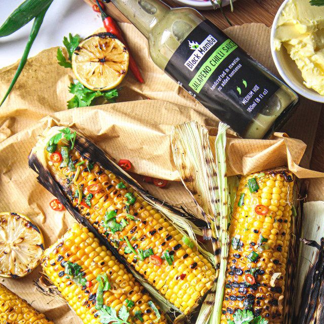 Black Mamba Foods Jalapeno Chilli Sauce, 180ml with food on the table