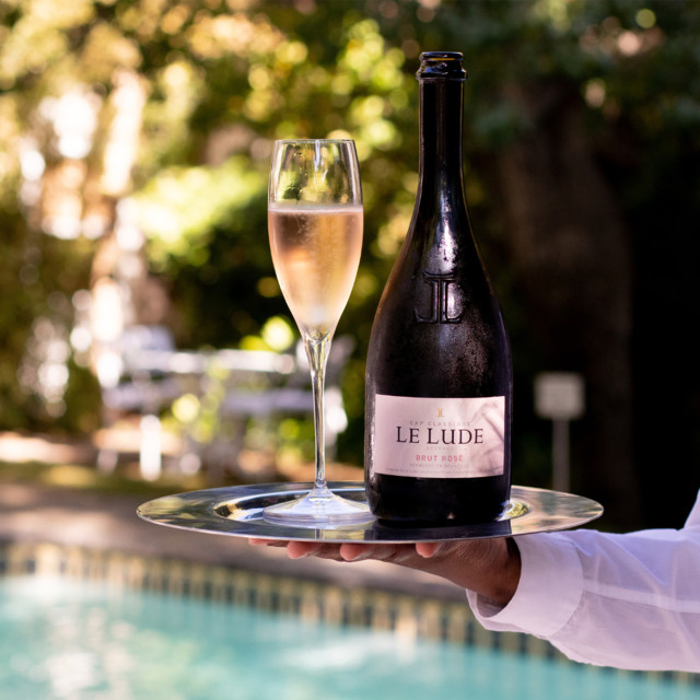 Le Lude Cap Classique Brut Ros� R�serve MCC In Gift Box, 2021 on a tray with a glass of brut rose