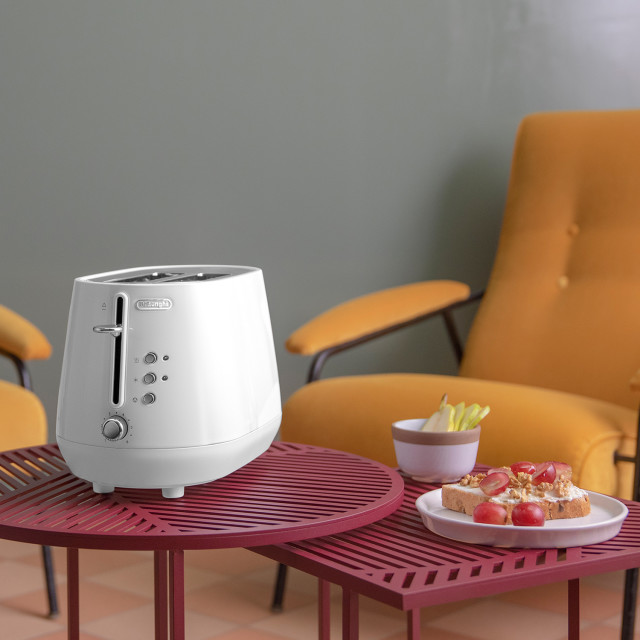 DeLonghi Eclettica 2-Slice Toaster - White on a coffee table