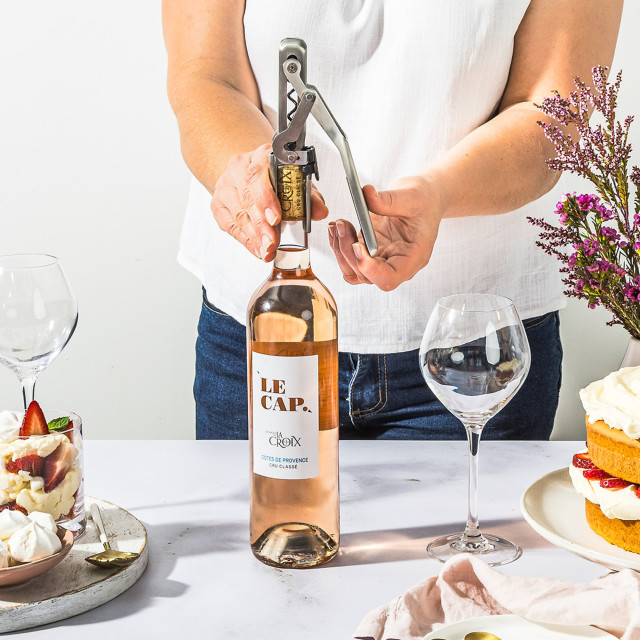 Dreamfarm Automatic Pocket Wine Opener on the table with a wine bottle