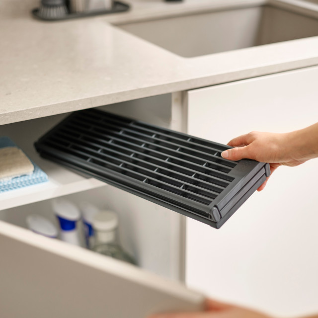Joseph Joseph Platform Foldable Over-Sink Drainer stored in a cupboard