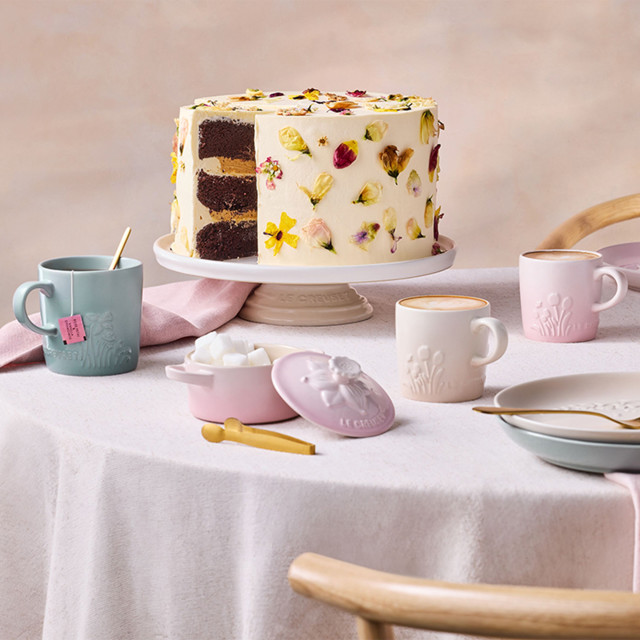 Le Creuset Jardin Relief Stoneware Cappuccino Mug, 200ml - Shell Pink with other colours on the table